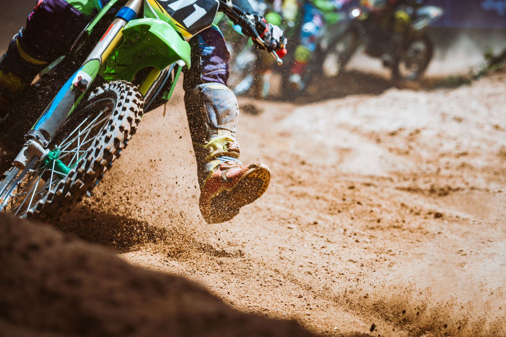 Close up part of mountain bikes race in dirt track with flying d